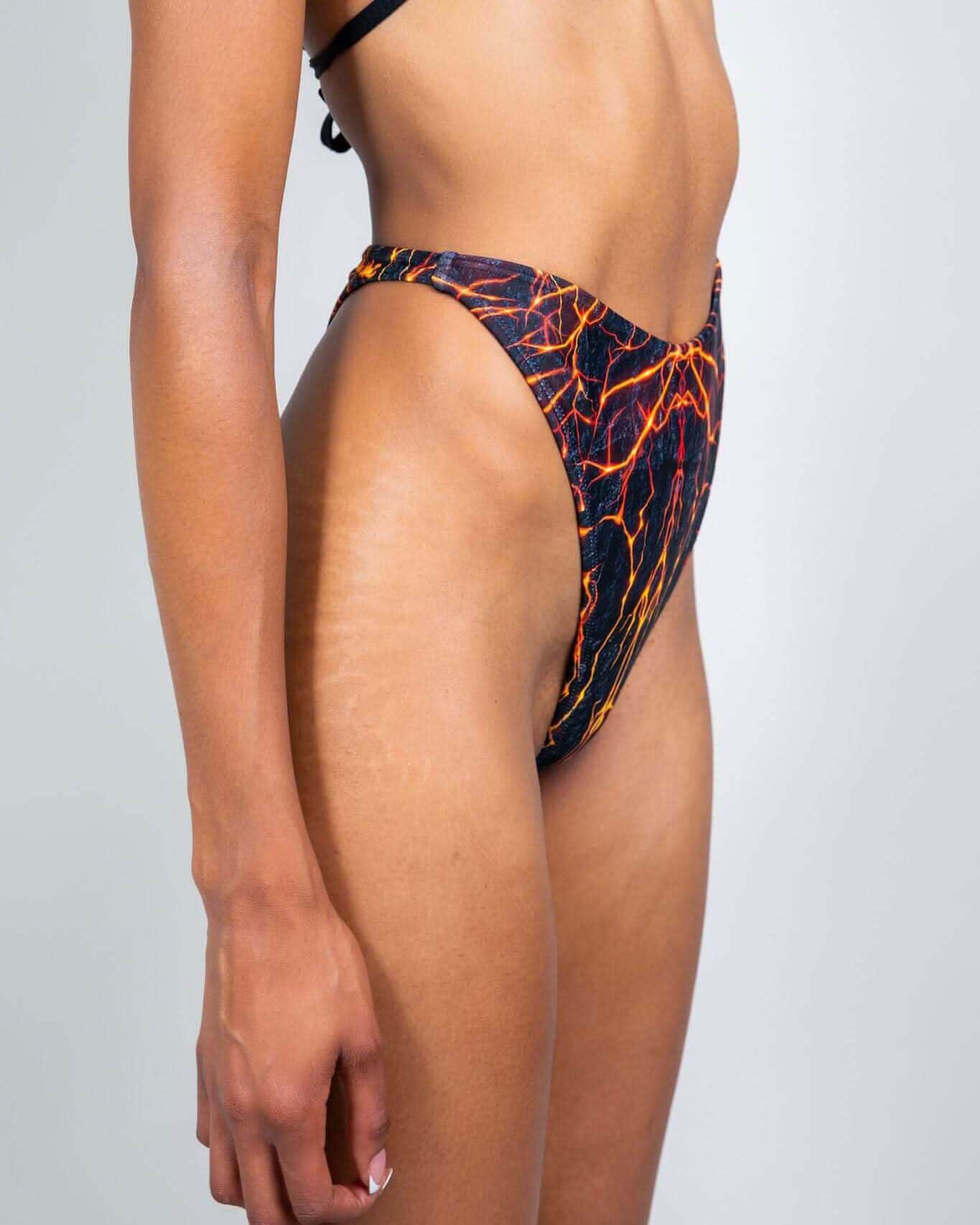 Magma retro thong rave pants with fiery lava print shown in side view on model