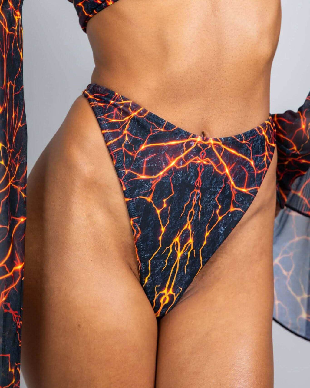 Magma print rave pants thong bottoms with fiery orange lava pattern, high-waisted festival outfit front view