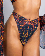 Magma print rave pants thong bottoms with fiery orange lava pattern, high-waisted festival outfit front view