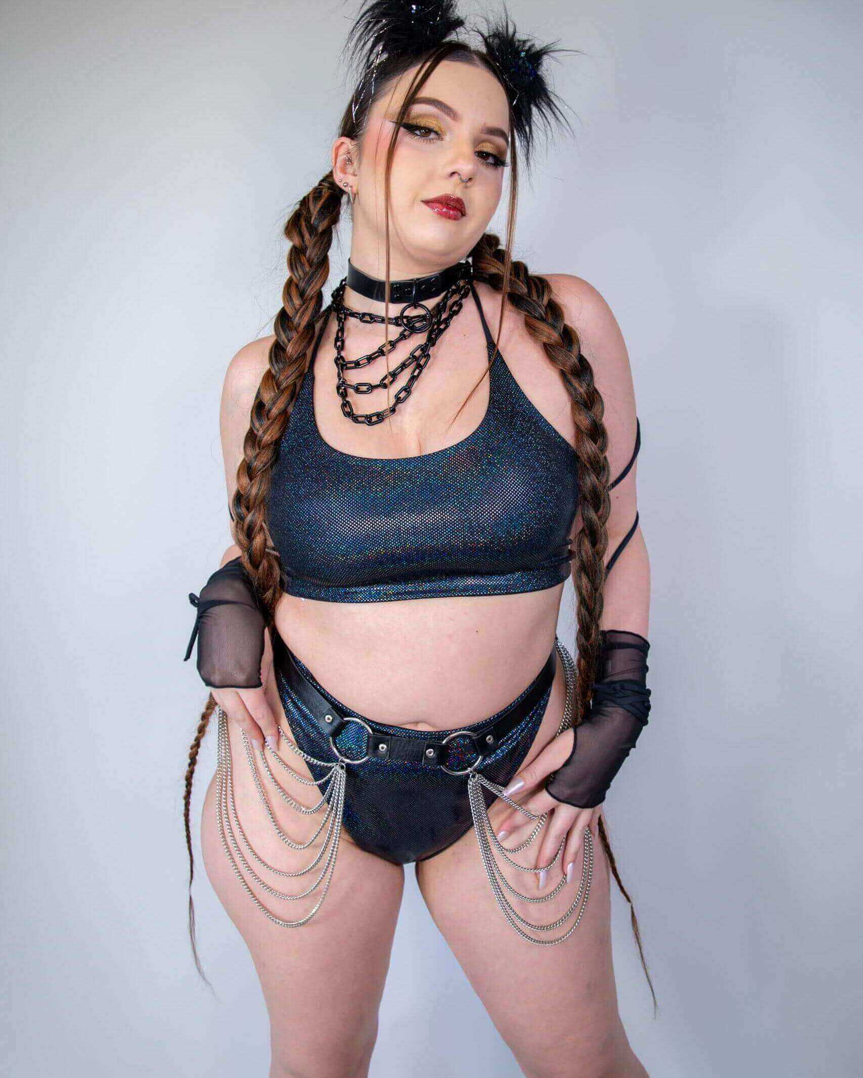 Model wearing midnight metallic rave pants and top with chain details in festival outfit front view