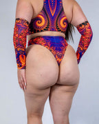 Back view of Radiance high-waisted rave pants with psychedelic swirl pattern in orange and purple