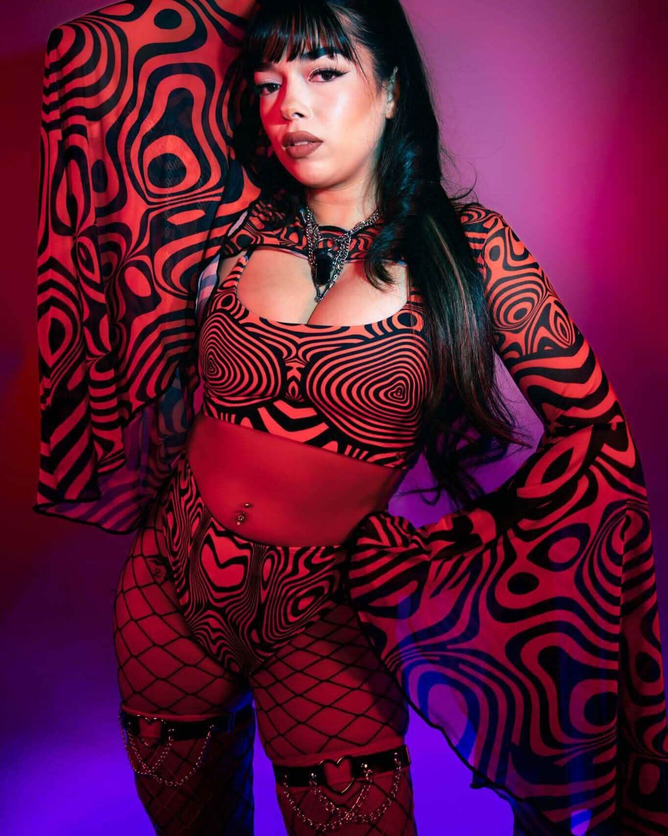 Woman in Red Void high waisted rave pants with matching jacket and fishnet stockings for festival outfit