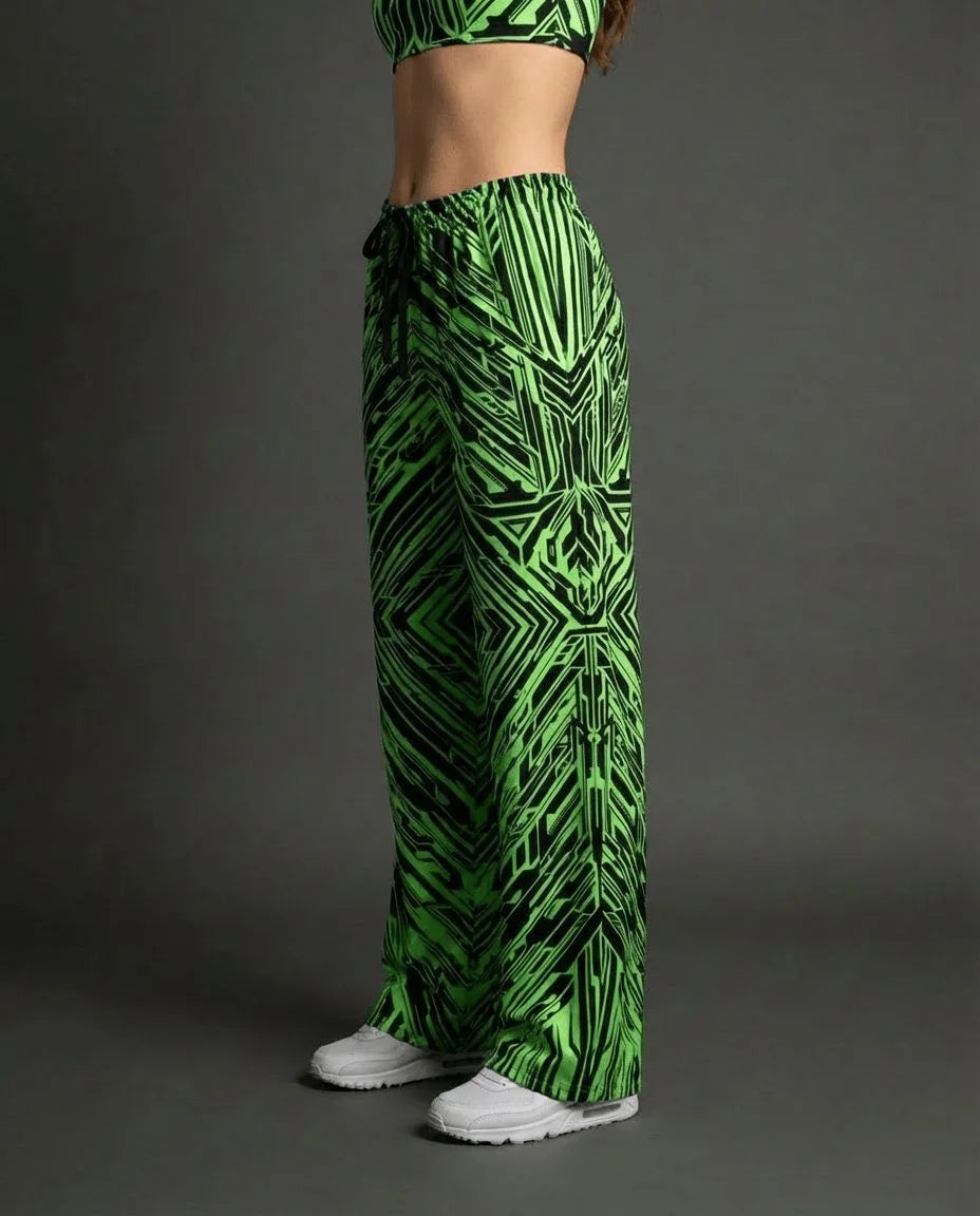 Model wearing Techtronix Lucy Pants, side view, showcasing the acid green and black angular circuit print, perfect for rave festivals.