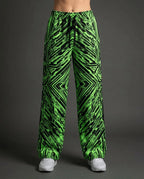 Techtronix Lucy Pants in neon green and black, featuring an angular circuit pattern, shown from the front on a model for rave festival fashion.
