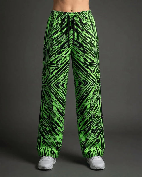 Techtronix Lucy Pants in neon green and black, featuring an angular circuit pattern, shown from the front on a model for rave festival fashion.