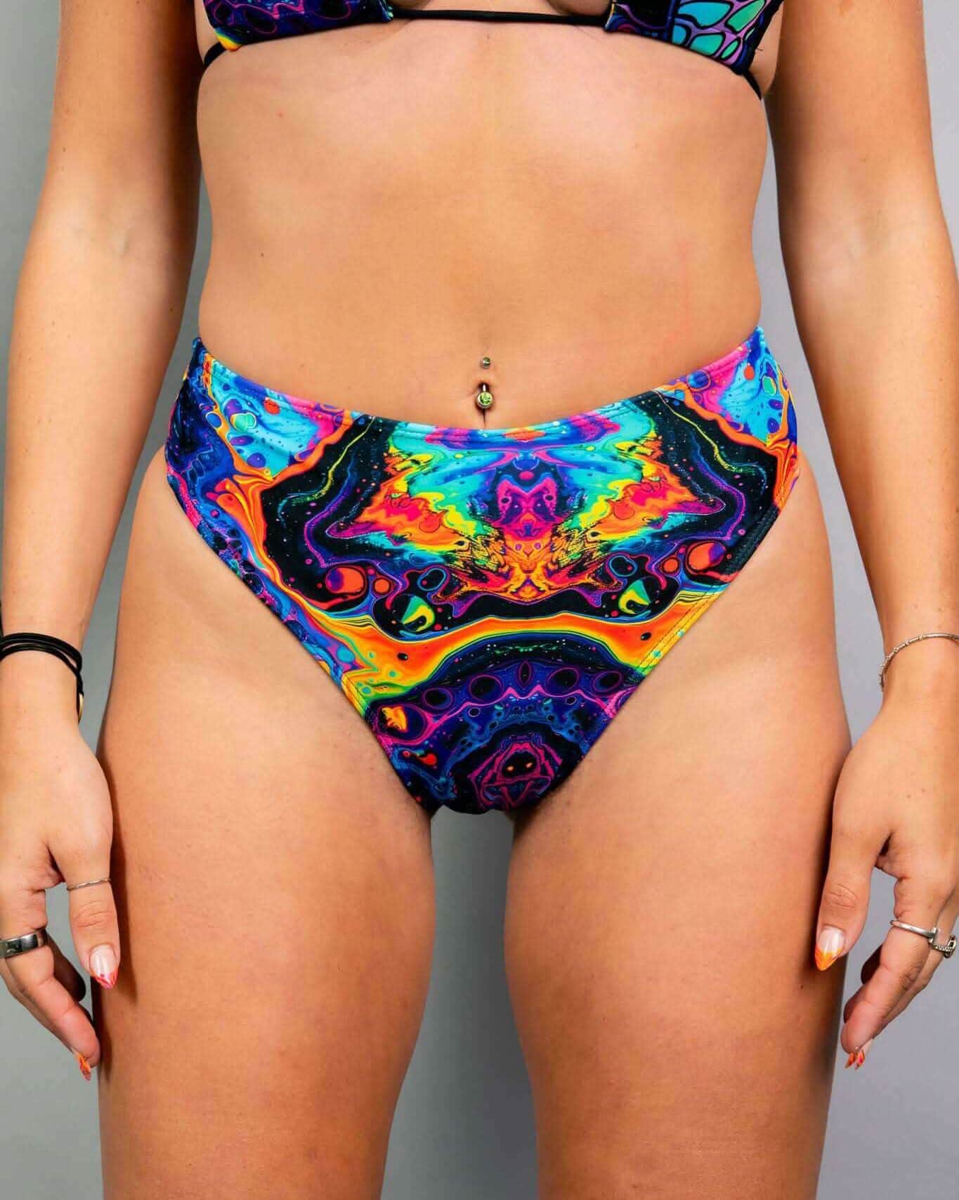 Vivid rainbow psychedelic rave pants high waisted thong bottoms festival wear front view on model