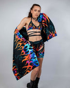 Blaze Festival Scarf draped over a model, showcasing the neon flame pattern in orange, blue, and purple on black.
