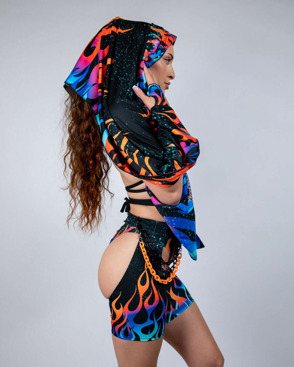 Blaze Festival Scarf worn by a model from the side, showcasing the neon flame pattern in orange, blue, and purple with teal galaxy speckles, perfect for rave or festival outfits.