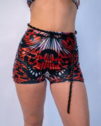 Lacewing High Waist Shorts in a vibrant red and black butterfly wing pattern, worn by a model from the front, perfect for rave or festival fashion.