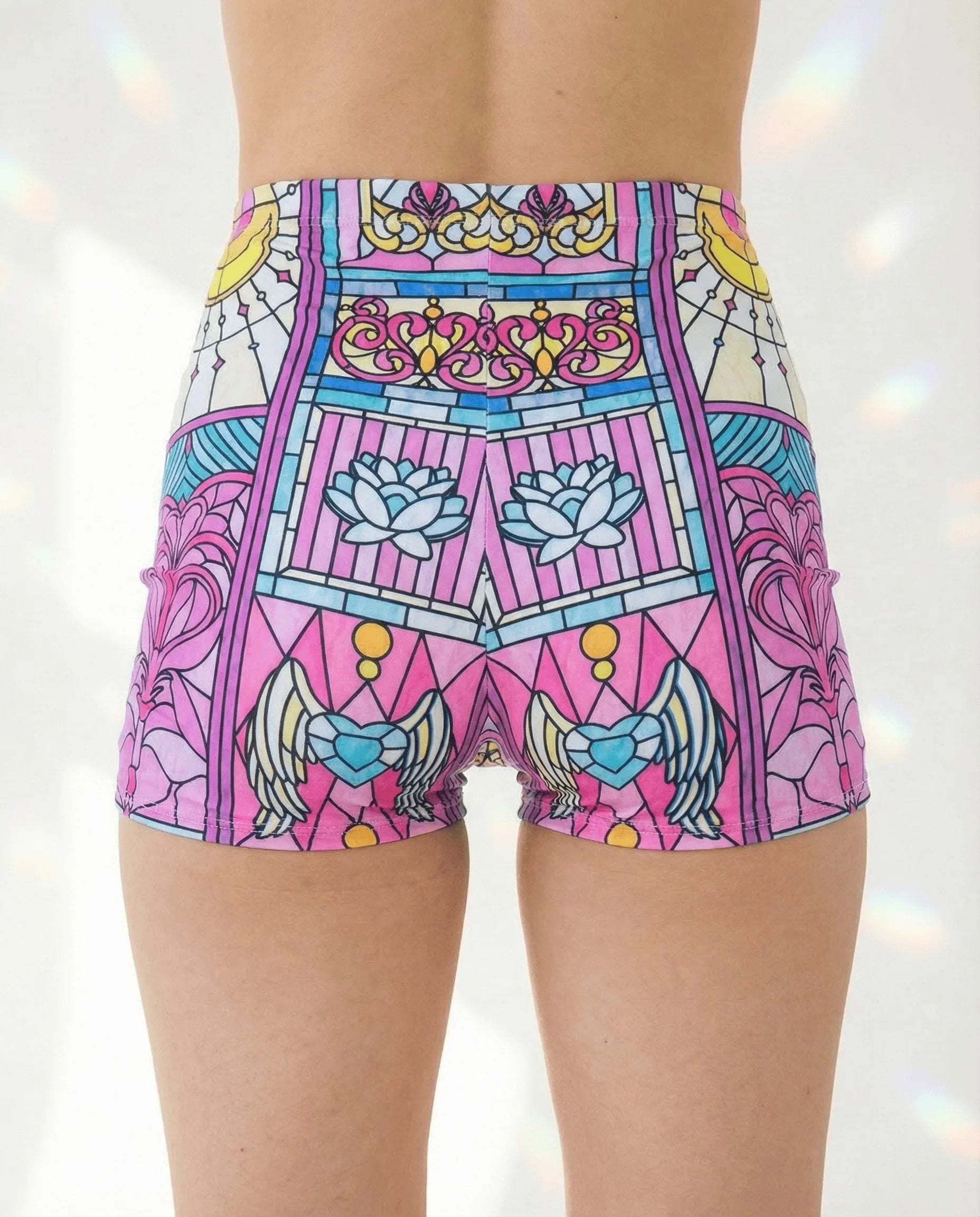 Moonlight High Waist Shorts from the back, showcasing the pastel pink, teal, and yellow stained-glass rave pattern.