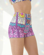 Moonlight High Waist Shorts from the side, featuring a vibrant pink, teal, and yellow stained-glass rave print.