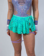 Calypso Lace Swirl rave skirt in turquoise worn with purple sequined festival top front view