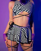 Distortion Swirl rave skirt with matching crop top in black white geometric patterns and leg harnesses
