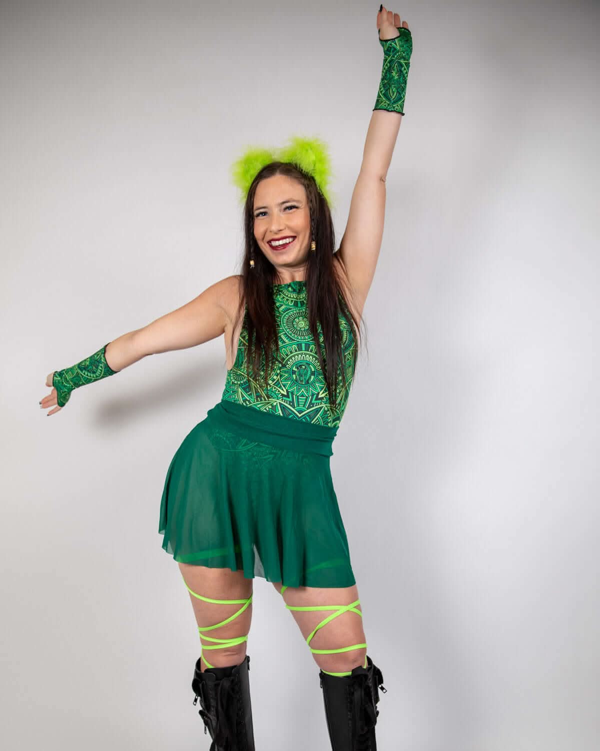 Model dancing in emerald mesh rave skirt with matching top and neon green accessories