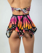 Back view of Monarch butterfly rave skirt with handkerchief hem in pink orange gradient festival wear