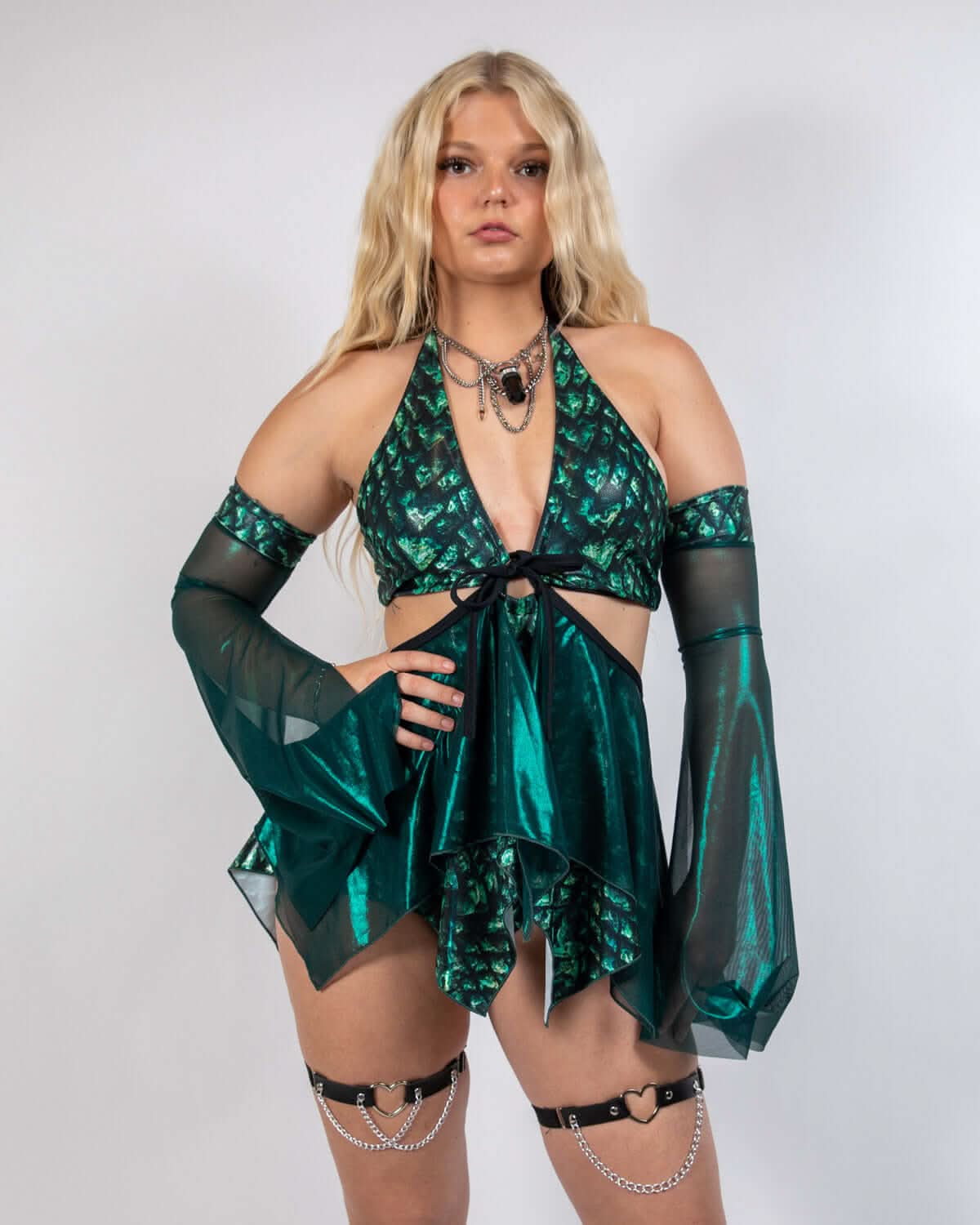 Blonde model wearing emerald green Predator rave skirt set with metallic fabric and flowing mesh sleeves