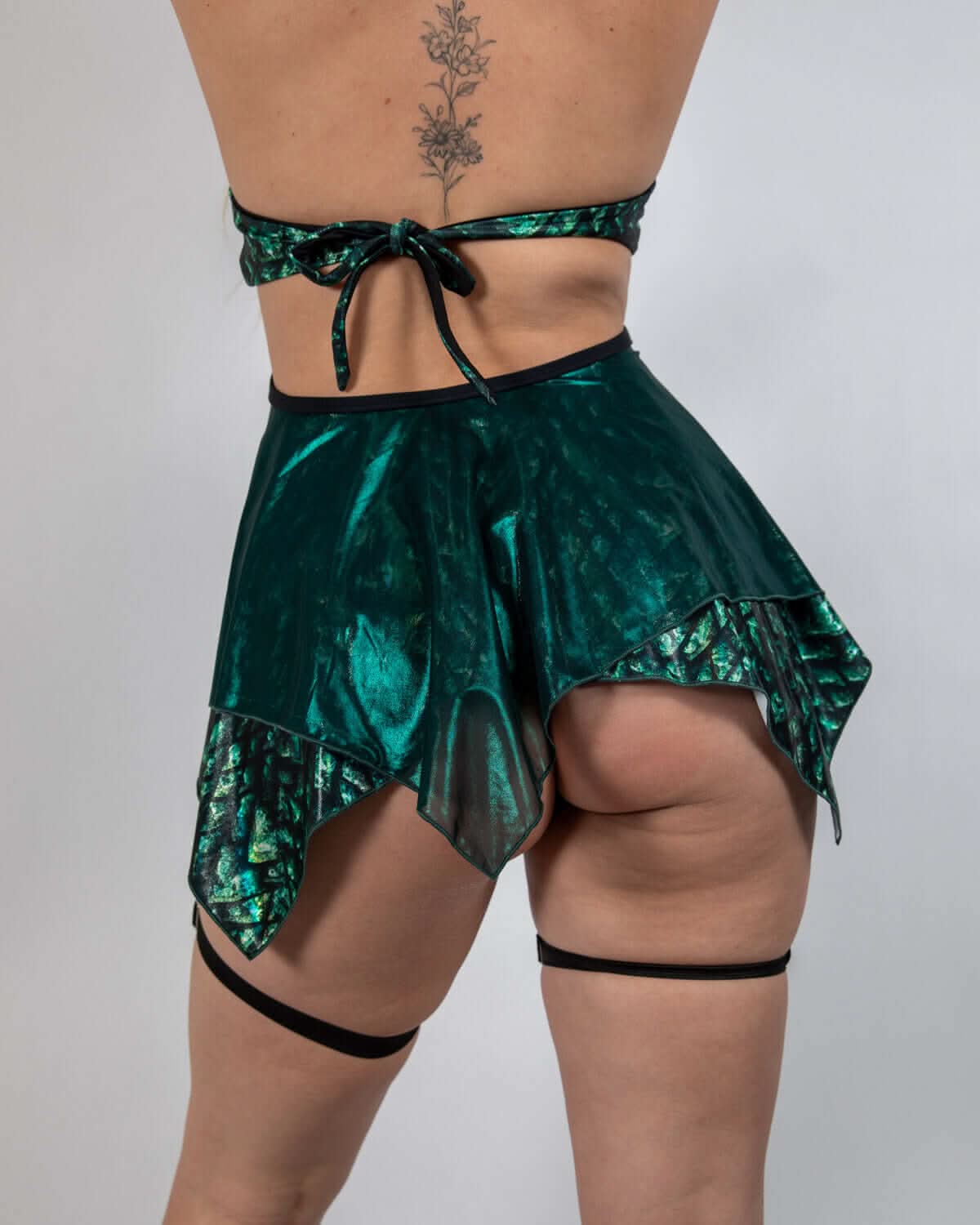 Back view of Predator Fairy rave skirt in metallic emerald green with asymmetrical pointed hem and matching bandeau top