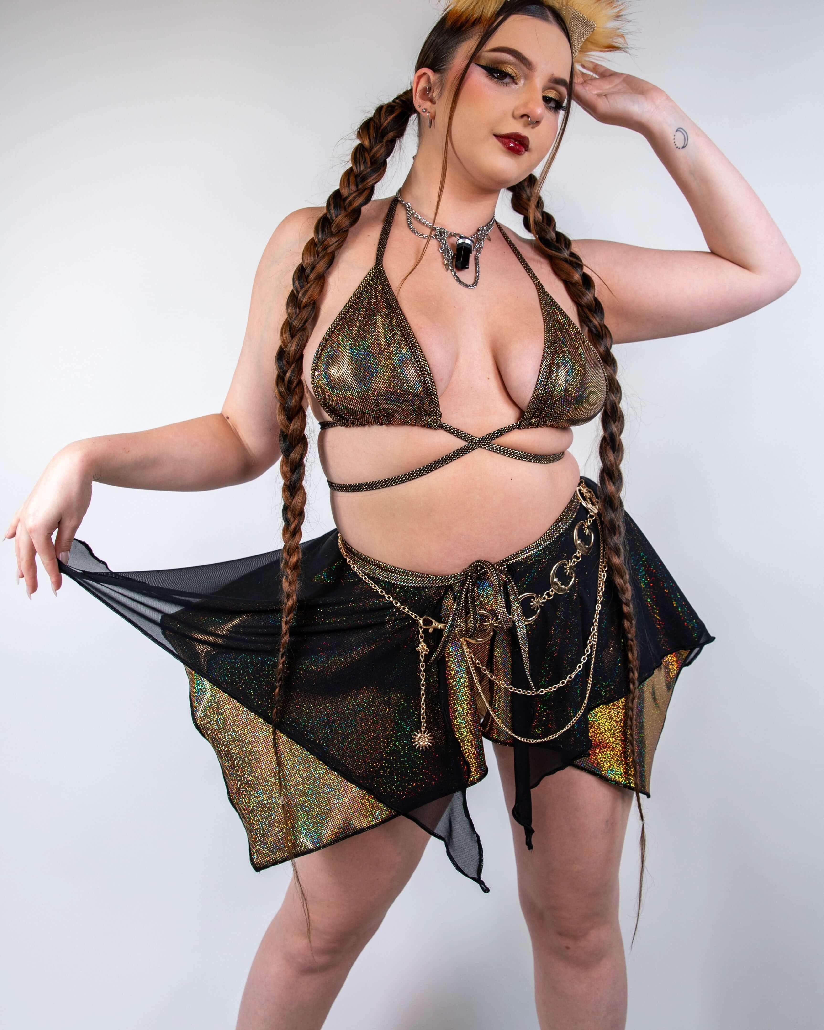 Model wearing Starfire golden holographic rave skirt with black mesh overlay in festival outfit front view