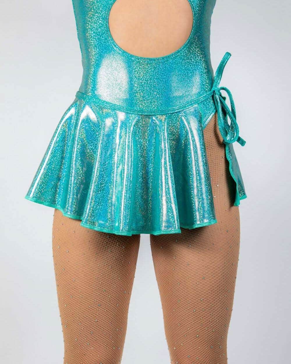Teal sparkle swirl rave skirt with pleated ruffle hem and wrap tie styling on model with fishnets