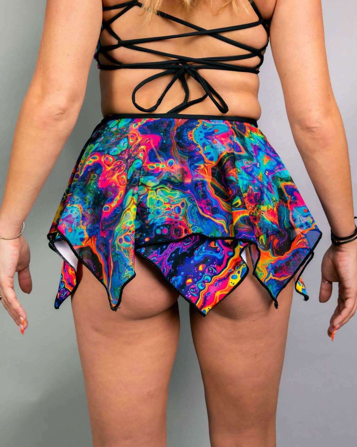 Vivid psychedelic rave skirt with handkerchief hem in multicolored swirls, festival outfit front view