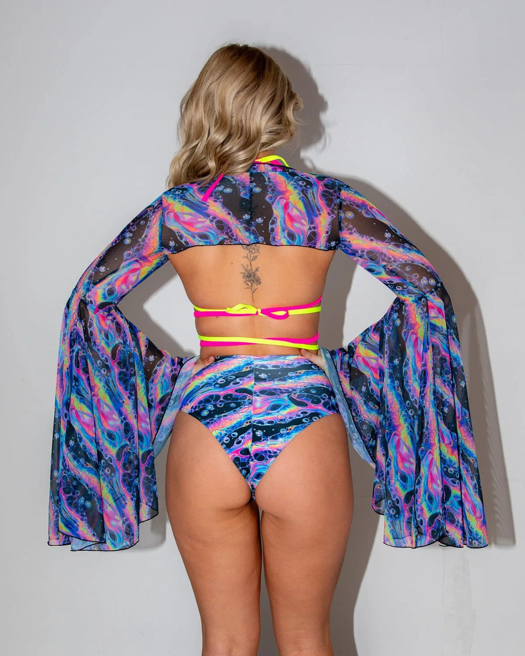 Acid Sky Mesh Bell Sleeves and matching bottoms from behind, showcasing the vibrant psychedelic pattern, perfect for rave festivals.