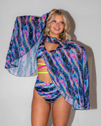 Acid Sky Mesh Bell Sleeves on a blonde model, front view, showcasing the vibrant psychedelic rave pattern.