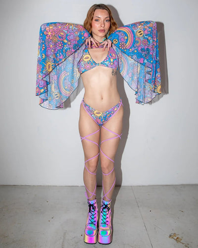 Groovy Mesh Bell Sleeves on a model from the front, showcasing the vibrant psychedelic pattern with suns, peace signs, and rainbows, perfect for a rave festival.