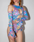 Groovy Spellcaster Arm Sleeves on a model, showcasing the vibrant pastel psychedelic print with peace signs and hearts, perfect for rave festivals.