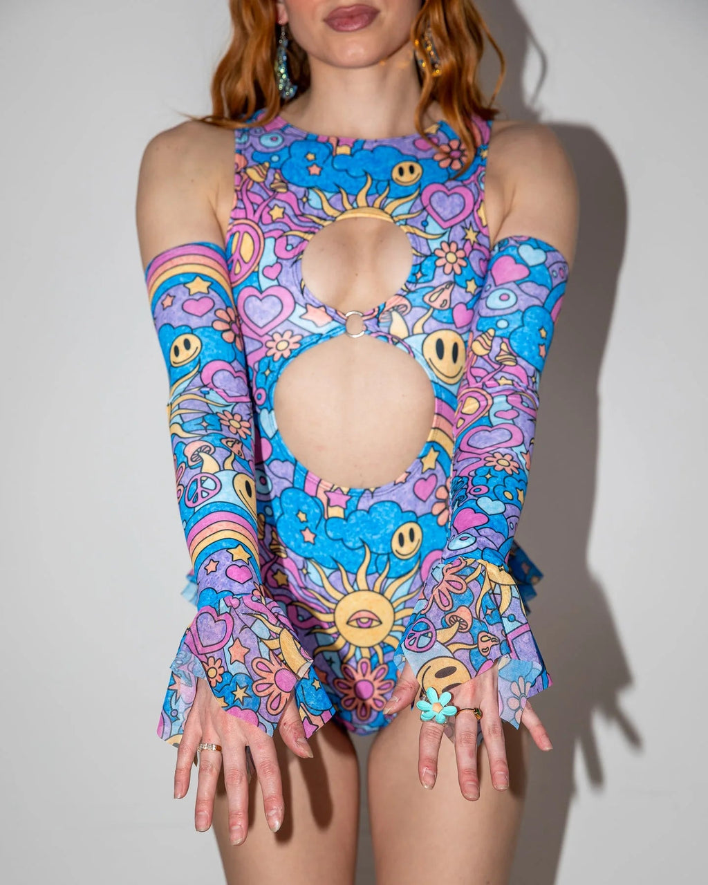Groovy Spellcaster Arm Sleeves on a model, front view, showcasing colorful pastel psychedelic rave sleeves with flared cuffs.