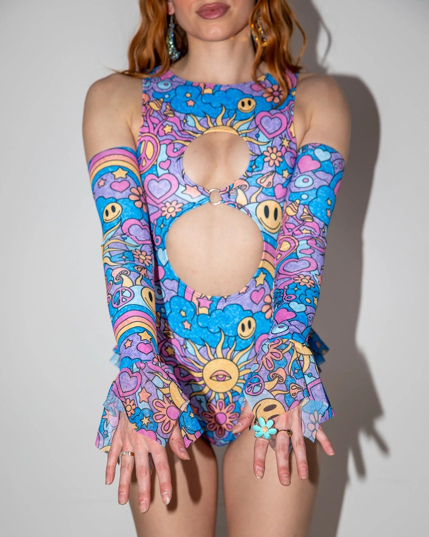 Groovy Spellcaster Arm Sleeves on a model, front view, showcasing colorful pastel psychedelic rave sleeves with flared cuffs.
