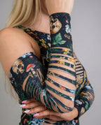Close-up of Poison Slit Arm Sleeves with a dark botanical print, skulls, and mushrooms, featuring horizontal slits, perfect for a festival look.