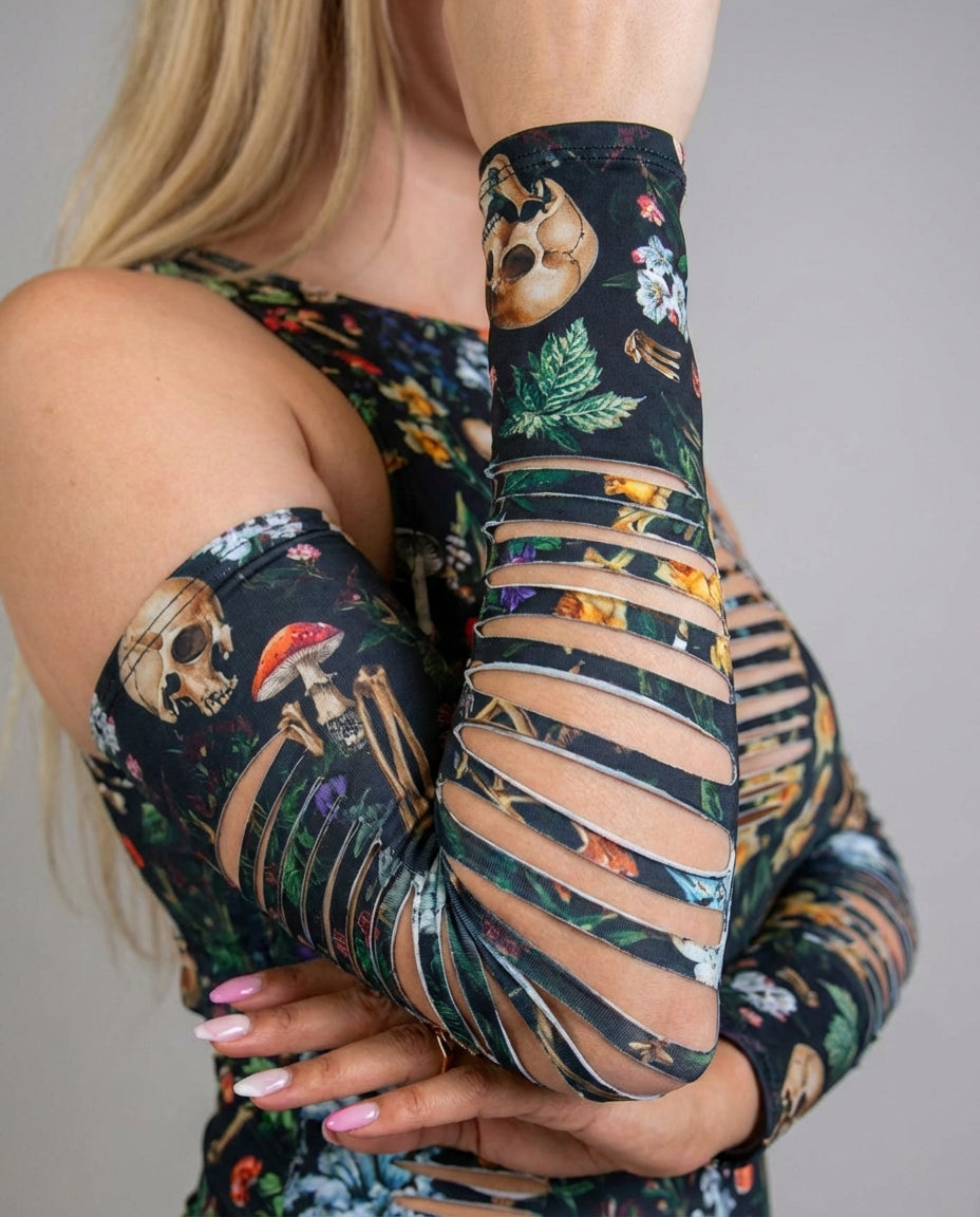 Close-up of Poison Slit Arm Sleeves with a dark botanical print, skulls, and mushrooms, featuring horizontal slits, perfect for a festival look.
