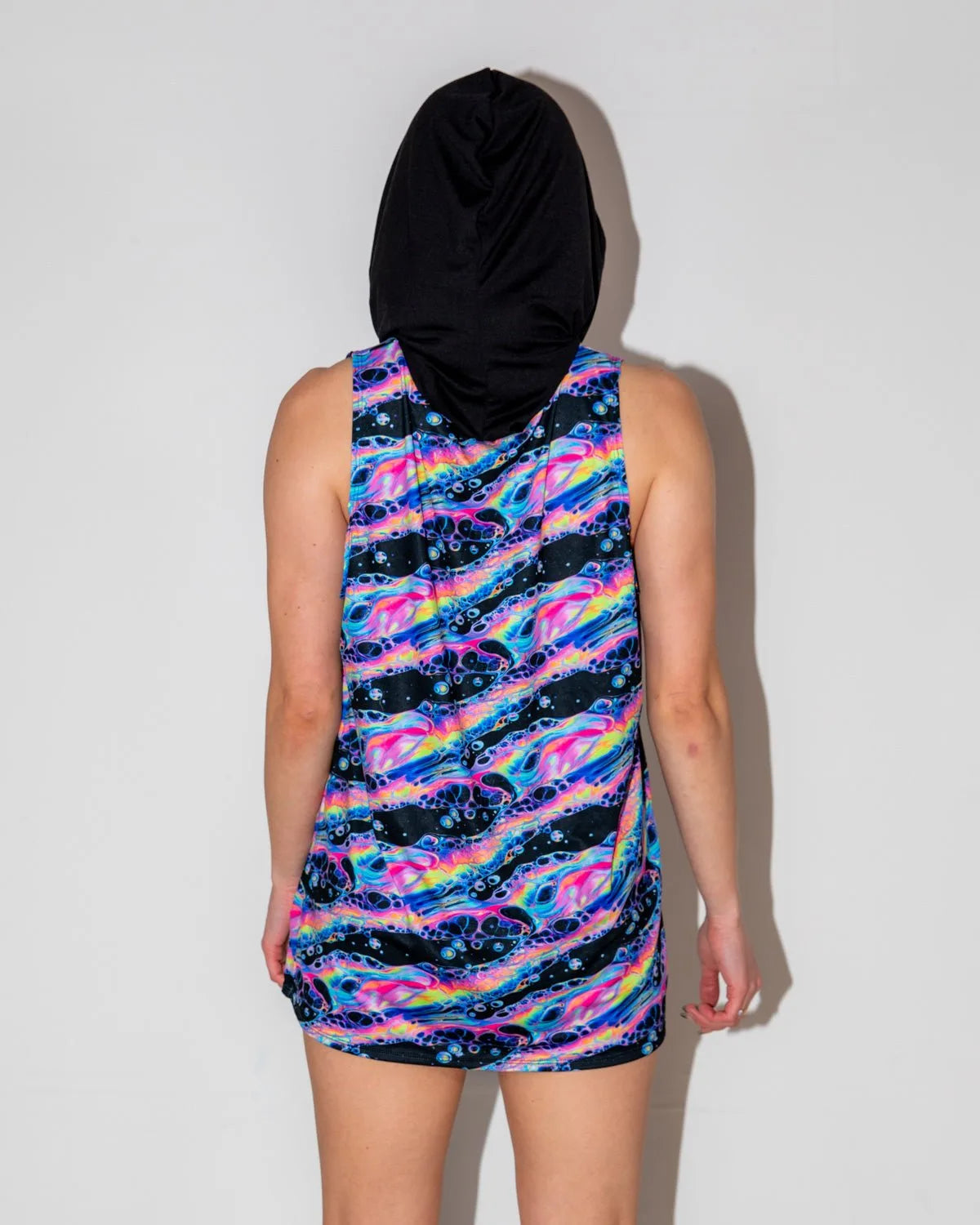 Acid Sky Men's Tank Top with Hood shown from the back, featuring vibrant neon pink, electric blue, and cosmic purple swirls, perfect for a rave festival.