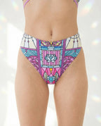 Moonlight High Waisted Thong in a vibrant stained-glass mosaic pattern, featuring magenta, cyan, and violet, worn by a model from the front, perfect for rave festivals.