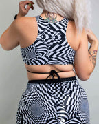 Back view of distortion geometric rave top with crisscross straps and matching festival bottoms