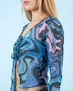 Glacial Sea Fairy Tie Top in blue, teal, lavender, and black liquid marble print, shown from the side on a blonde model, perfect for rave festivals.