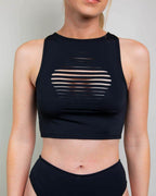 Woman wearing matte black slit rave top with horizontal cutouts, front view festival outfit