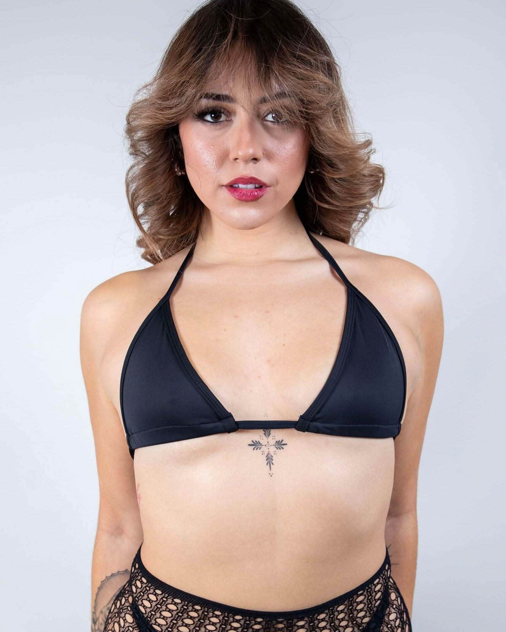 Woman wearing matte black triangle rave top with halter ties, festival bikini front view