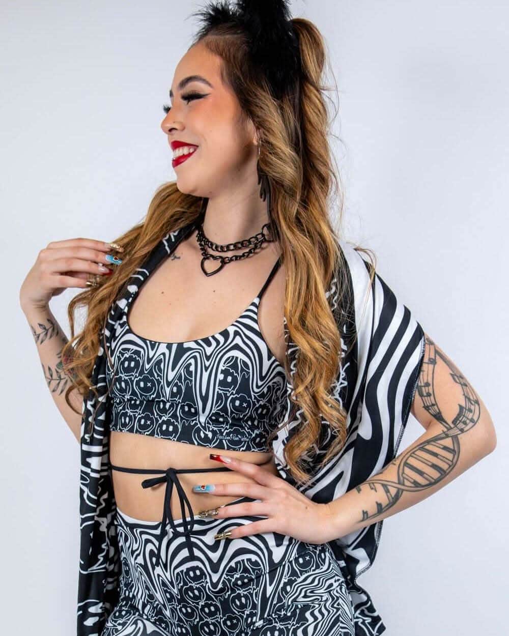 Model wearing black white Meltdown rave top bikini set with matching kimono festival outfit profile pose