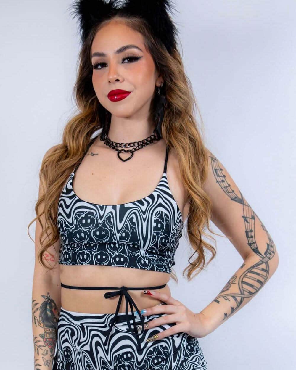 Meltdown psychedelic rave top with swirled smiley face print modeled against white background for festival outfit styling