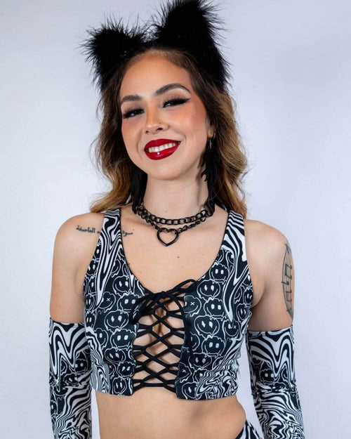 Model wearing black and white Meltdown lace up rave top with smiley face pattern and matching arm sleeves