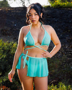 Model wearing mint mesh rave top bikini style with wrap straps in outdoor festival setting