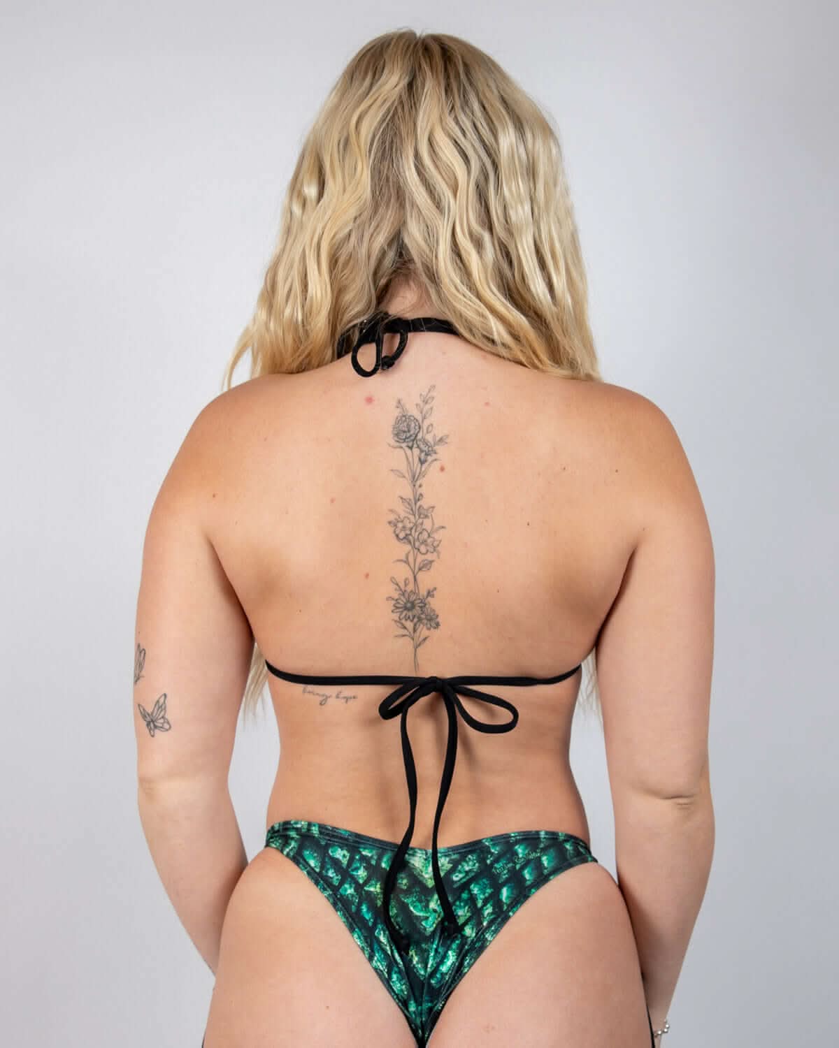 Back view of Predator strappy rave top with tie closures and green holographic festival bottoms