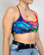 Model wearing Saurian reversible rave top in rainbow tie-dye with jeans and layered necklaces front view