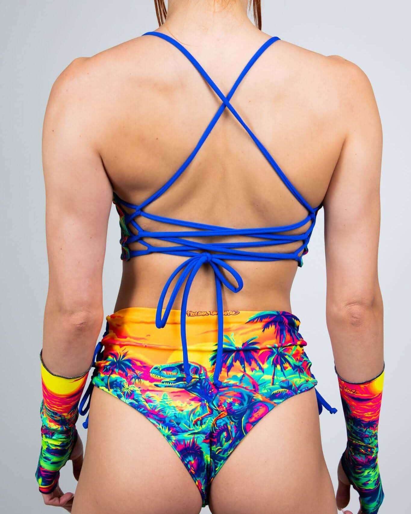 Back view of Saurian reversible rave top with blue cross-back straps and tropical print festival outfit