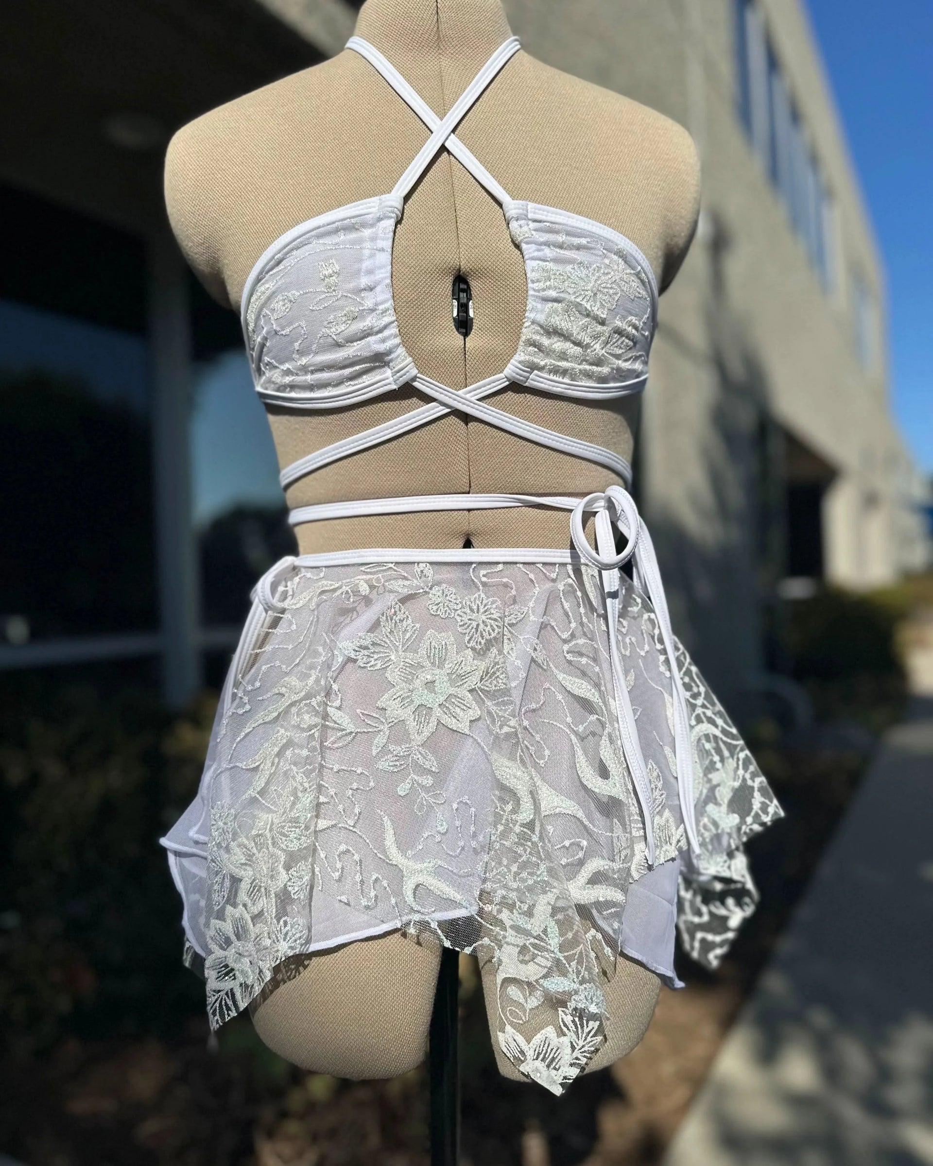 Seraphina Wrap Bikini Top in white floral lace on a mannequin, front view, perfect for a festival.