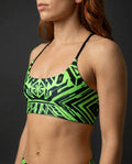 Techtronix Lush Top in neon green and black, featuring a cyber-tribal geometric pattern, worn by a model from the side, perfect for rave festivals.