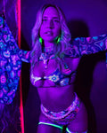 Vivid Shroomie Wonder rave top with psychedelic mushroom print glowing under blacklight festival lighting