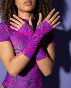 Model showcasing Vanish rave arm sleeves with pink purple swirls in defensive hand pose