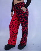 Red Batty 50/50 Lucy Pants - UV Red worn by model, showcasing unique UV-reactive bat design for rave outfits.